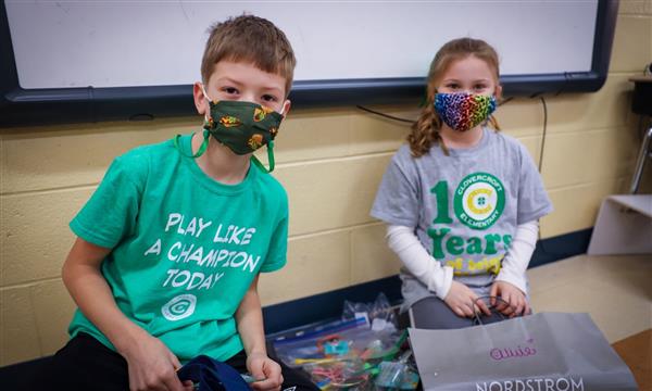 two students smile while looking through products they bought